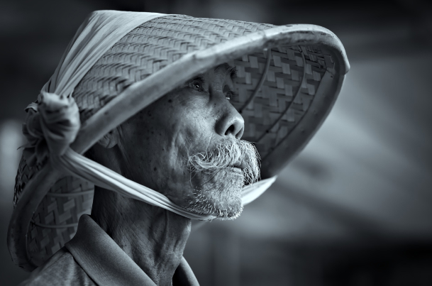 black and white portrait of the old man with a moustache wearing a bamboo cap